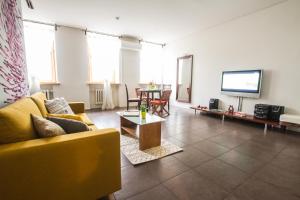 a living room with a yellow couch and a tv at SPACIOUS 3 ROOM CENTRAL APARTMENT 56d in Kaunas