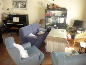 a living room with a couch and chairs and a piano at Camino del Castillo in Jimena de la Frontera