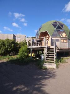 a house with a green roof and a wooden staircase at Dune & Domes Pichilemu in Pichilemu