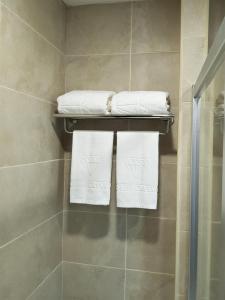 un bagno con asciugamani bianchi su una mensola di Crystal Resort a Bakuriani