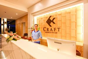 CRAFT Resort & Villas, Phuket Town في فوكيت تاون: امرأة تقف أمام متجر حرفي