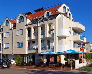 a large building with umbrellas in front of it at Ravda Bay Guest House in Ravda