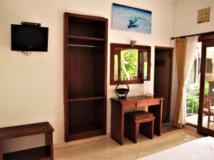 a room with a desk and a tv on a wall at La Bila Dive Resort Amed in Amed