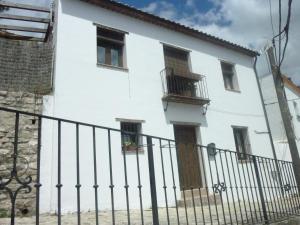 ヒメナ・デ・ラ・フロンテラにあるCamino del Castilloの窓と柵のある白い家