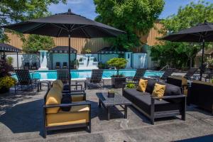 eine Terrasse mit Sofas und Sonnenschirmen neben einem Pool in der Unterkunft Mount View Hotel & Spa in Calistoga