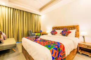 a hotel room with a bed and a chair at FabHotel Casa Kiara With Pool Side Bar, Calangute in Calangute