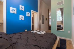 een slaapkamer met een blauwe muur en een bed bij Trifecta 10 Min Walk to 7th St Market Superhost in Charlotte