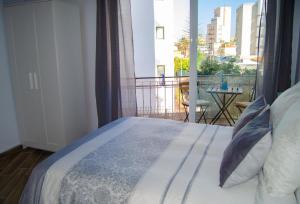 ベナルマデナにあるApartamento Biznagaのベッドルーム1室(ベッド1台付)、景色を望むバルコニーが備わります。