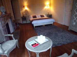 a living room with a bed and a table with a coffee table at Domaine de Bel Air in Cérans-Foulletourte