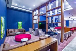 錫瓦斯的住宿－The Green Park Sivas，客厅配有皮革家具和红色地毯。