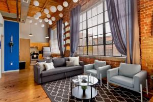 a living room with a couch and chairs and a table at Trifecta Historic Brick 2BR Getaway Superhost in Durham