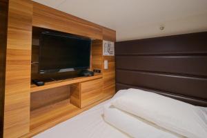 um quarto com uma cama e uma televisão de ecrã plano em Hiroshima no Oyado em Hiroshima