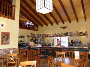 un restaurante con un bar con dos personas en Bungalows Peña Montañesa, en Aínsa