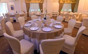 a dining room with a table and chairs with plates and silverware at Vip Motel Restaurant in Haţeg