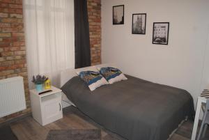a bedroom with a bed with two pillows on it at Stay99 Apart in Poznań
