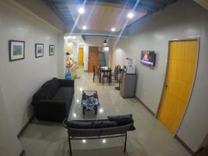 uma sala de estar com um sofá e uma mesa em Modern Apartment 301 em Dagupan