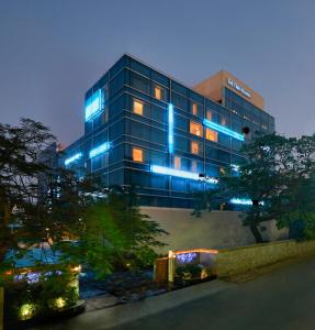 un edificio con luces azules por la noche en Taj Club House en Chennai