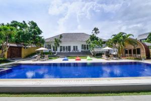 a swimming pool in front of a house at Villa Del Mar Canggu by Kanaya Hospitality in Canggu