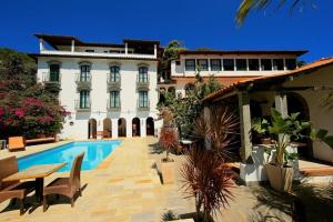 a large building with a swimming pool in front of a building at Jardim da Marambaia in Barra de Guaratiba