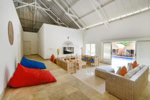 a living room with a couch and a table at Villa Del Mar Canggu by Kanaya Hospitality in Canggu