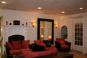 a living room with red chairs and a fireplace at Hotel Alexandre III in Cannes