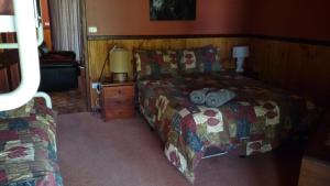 ein Schlafzimmer mit einem Bett, einer Lampe und einem Sofa in der Unterkunft Wrenwood Chalets in Augusta