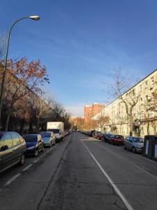 una calle vacía con coches aparcados a un lado de la carretera en 16 Mirasierras, en Madrid