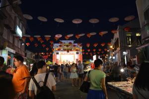 a crowd of people walking around a street with umbrellas at 1511 Guest House in Malacca