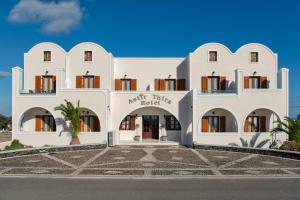 een wit gebouw met een boog voor de deur bij Astir Thira Hotel in Fira