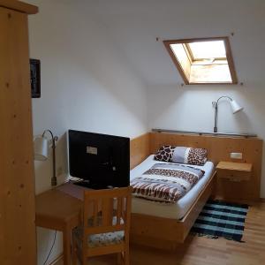 Schlafzimmer mit einem Bett, einem TV und einem Schreibtisch in der Unterkunft Lenggrieser Hof in Lenggries