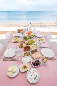 ein rosa Tisch mit Tellern voller Essen am Strand in der Unterkunft Exotic Hotel & SPA in Boghaz