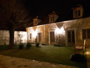 una casa con luces al costado de ella por la noche en L'ancien Presbytère, en Coye-la-Forêt