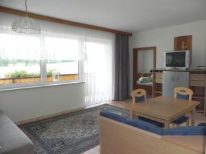 a living room with a table and chairs and a television at Apartments Kleinseeblick in Sankt Kanzian