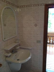 y baño con lavabo y espejo. en Albergo Garnì Ajarnola, en Auronzo di Cadore