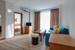 a living room with a blue couch and a table at Jupiter 1 Family Hotel in Balchik