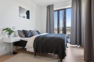 a white bedroom with a bed and a window at BJØRVIKA APARTMENTS, Opera Area, Oslo city center in Oslo