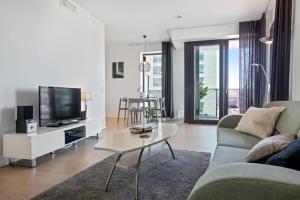 a living room with a couch and a tv and a table at BJØRVIKA APARTMENTS, Opera Area, Oslo city center in Oslo