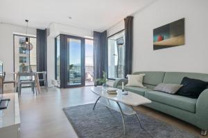 een woonkamer met een groene bank en een tafel bij BJØRVIKA APARTMENTS, Opera Area, Oslo city center in Oslo