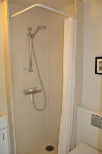 La salle de bains est pourvue d'une douche avec rideau de douche. dans l'établissement Lundsgaard Bed & Breakfast, à Fåborg