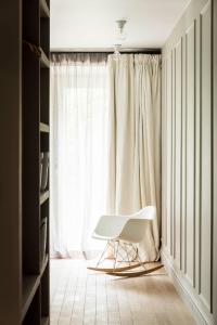 einen weißen Stuhl in einem Zimmer mit Fenster in der Unterkunft ANNEXE 1888 in Magland