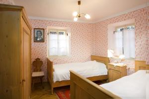 a bedroom with two beds and pink wallpaper at House, Garden and a Green Cat in Bled