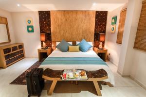 Un dormitorio con una cama con una bandeja de comida. en Calypso Hôtel en Toamasina