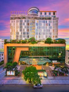 ein großes Gebäude mit einem Parkplatz davor in der Unterkunft Galina Hotel & Spa in Nha Trang