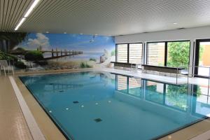a large swimming pool with a mural on the wall at GDA Hotel Göttingen in Göttingen