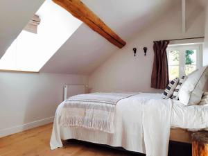 een slaapkamer met een wit bed op zolder bij L'ancien Presbytère in Coye-la-Forêt