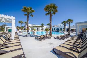 a pool with chaise lounge chairs and palm trees at Centro Vacanze Poker in Casalbordino