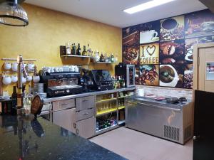 a kitchen with a counter and a bar with drinks at Hostal Restaurante El Abuelo in Trobajo del Camino