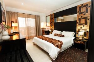 a bedroom with a large bed and a large window at Calypso Hôtel in Toamasina