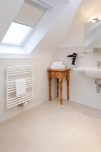 a bathroom with a sink and a skylight at Weisse Düne - West in Wenningstedt