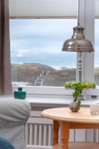 a table with a lamp in front of a window at Weisse Düne - West in Wenningstedt